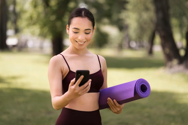 Retrato de mujer joven comprobando el teléfono móvil