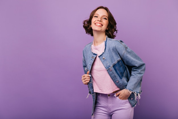 Retrato de mujer joven confiada en chaqueta de gran tamaño de moda. Elegante niña sonriente posando con placer.