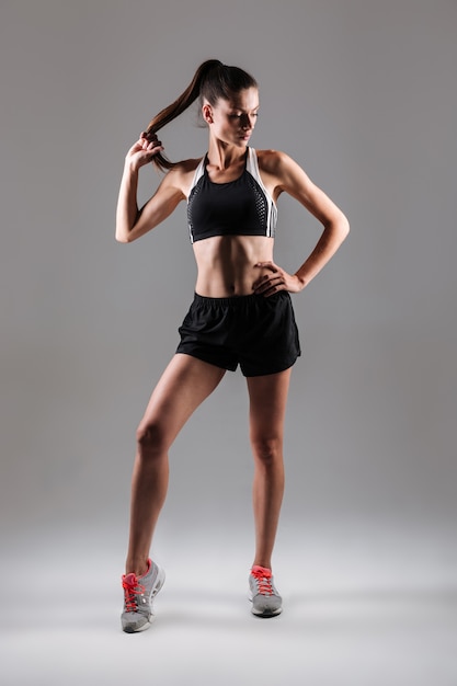 Retrato de una mujer joven delgada fitness posando mientras está de pie