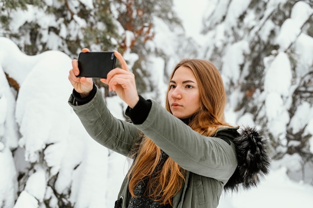 Foto gratuita retrato de mujer joven en día de invierno tomando fotos