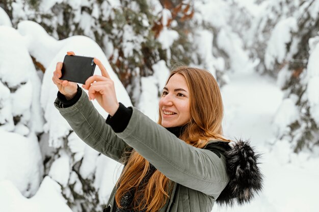 Retrato de mujer joven en día de invierno tomando fotos