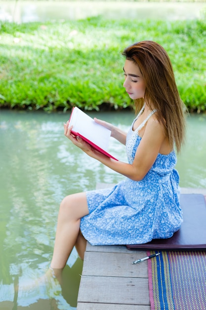 Retrato mujer joven con diario en el parque