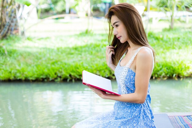 Retrato mujer joven con diario en el parque