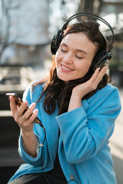 Retrato de mujer joven disfrutando de la música al aire libre