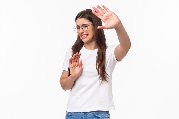 Retrato de mujer joven disgustada y reacia, tirando de las manos