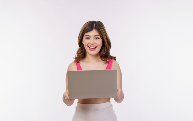 Retrato de mujer joven emocionada trabajando en equipo portátil aislado sobre fondo blanco.