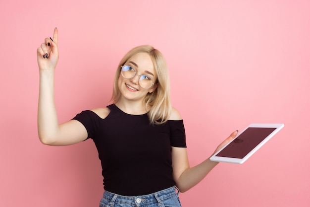 Retrato de mujer joven con emociones brillantes en la pared del estudio de coral rosa