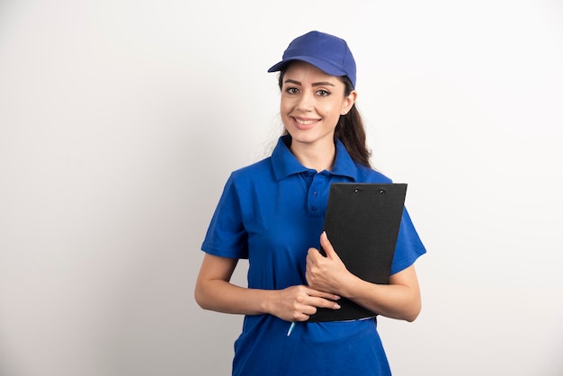 Foto gratuita un retrato de una mujer joven de entrega con portapapeles. foto de alta calidad