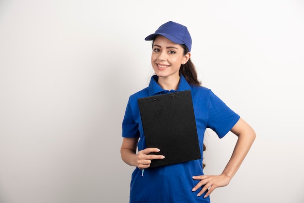 Un retrato de una mujer joven de entrega con portapapeles. Foto de alta calidad