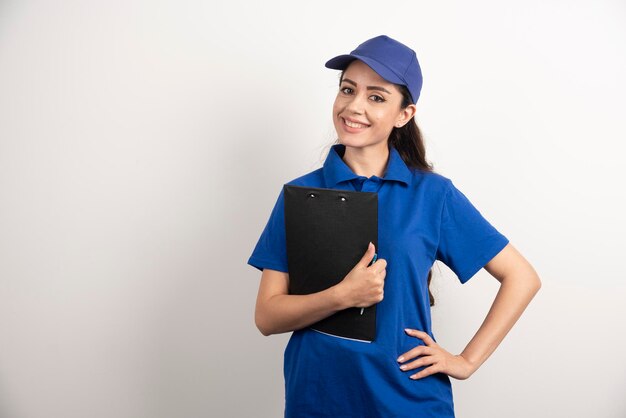 Un retrato de una mujer joven de entrega con portapapeles. Foto de alta calidad