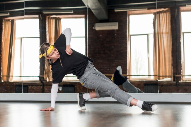 Retrato de una mujer joven con estilo practicando danza en el estudio