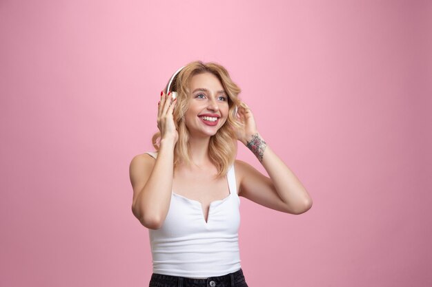 Retrato de mujer joven en estudio rosa. Hermosa modelo rubia