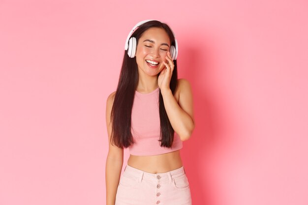 Retrato de mujer joven expresiva con auriculares escuchando música