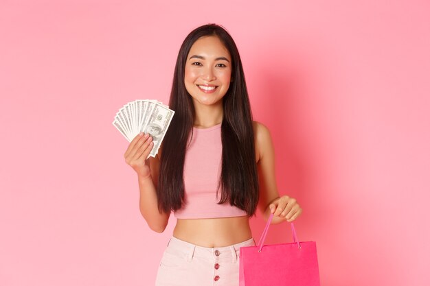 Retrato de mujer joven expresiva con bolsas de la compra y dinero