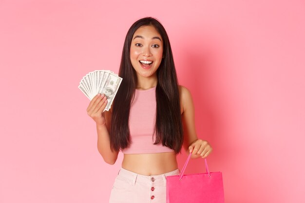 Retrato de mujer joven expresiva con bolsas de la compra y dinero