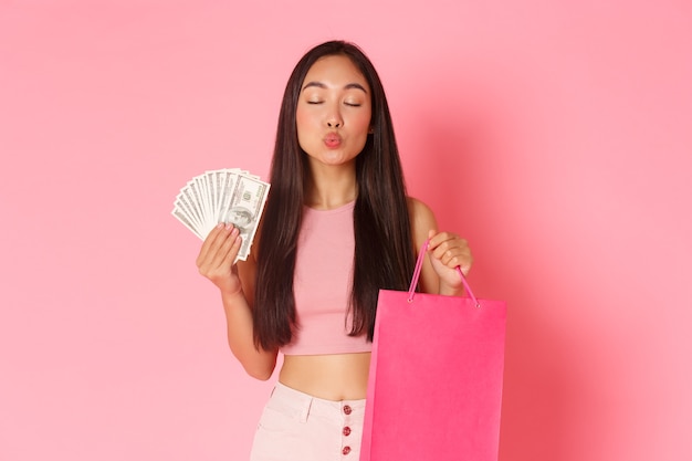 Retrato de mujer joven expresiva con bolsas de la compra y dinero