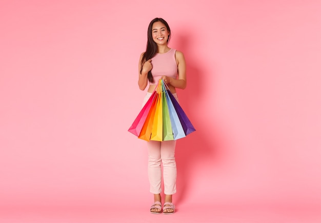 Retrato de mujer joven expresiva con bolsas de la compra.