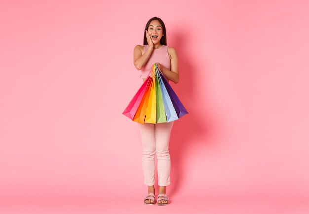 Retrato de mujer joven expresiva con bolsas de la compra.