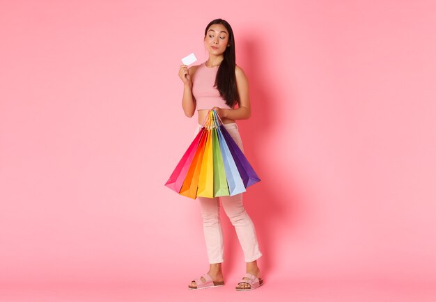 Retrato de mujer joven expresiva con bolsas de la compra.