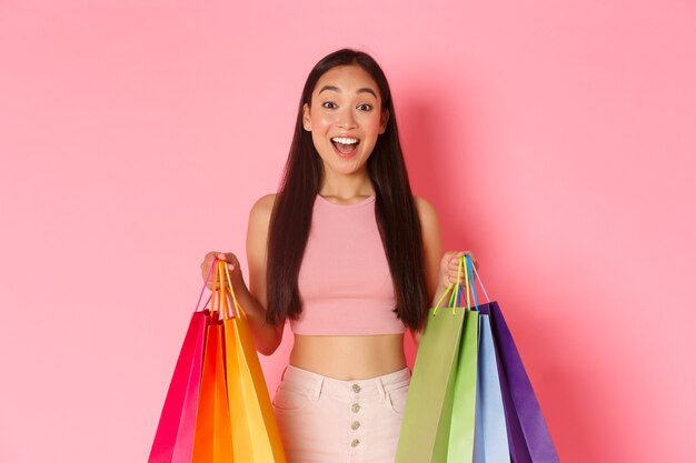 Retrato de mujer joven expresiva con bolsas de la compra.