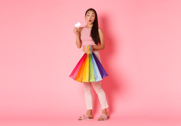 Retrato de mujer joven expresiva con bolsas de la compra.