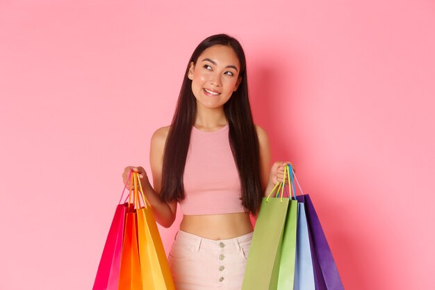 Retrato de mujer joven expresiva con bolsas de la compra.