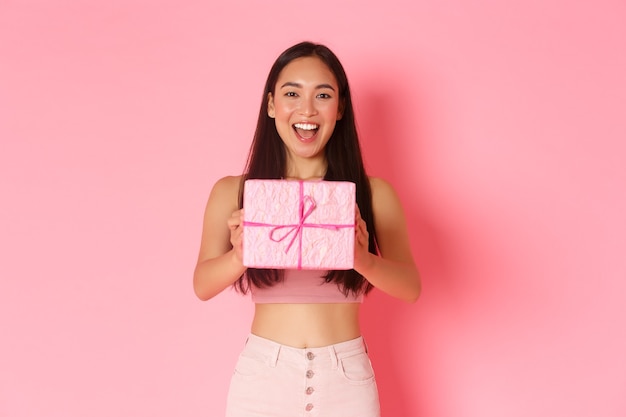 Retrato de mujer joven expresiva con caja de regalo