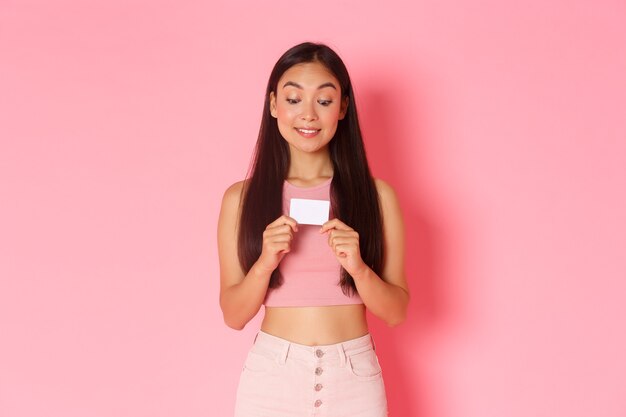 Retrato de mujer joven expresiva con tarjeta de crédito