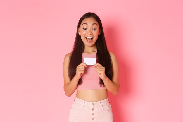 Retrato de mujer joven expresiva con tarjeta de crédito