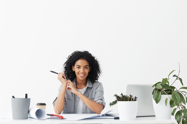 Retrato de mujer joven feliz arquitecto sonriendo ampliamente