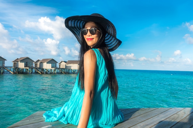 Retrato de mujer joven feliz en la hermosa villa de agua en la isla de Maldivas. Viajes y vacaciones. Tiro al aire libre