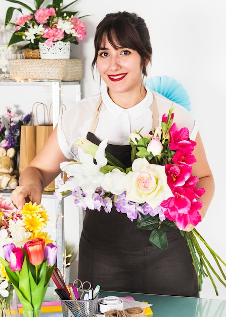 Retrato de una mujer joven feliz con ramo de flores