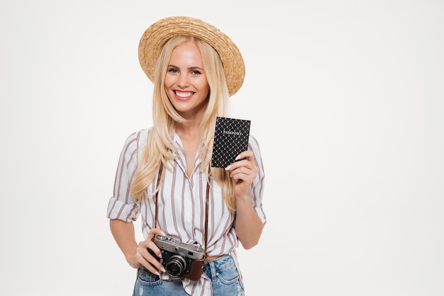 Retrato de una mujer joven feliz con sombrero con cámara