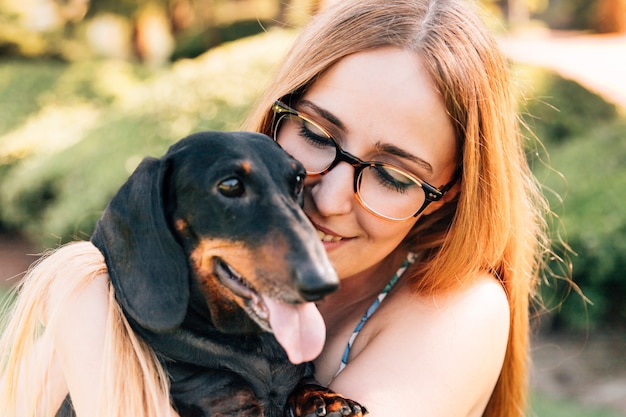 Foto gratuita retrato de una mujer joven feliz con su perro