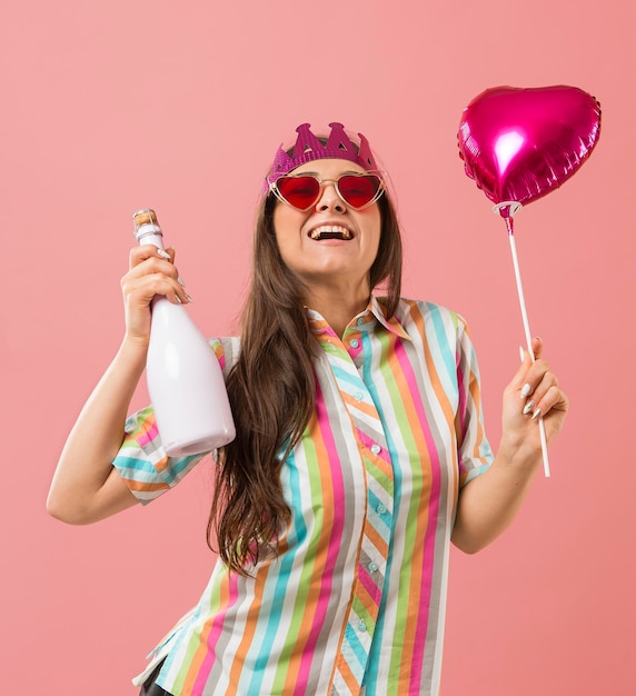 Retrato, mujer joven, en, fiesta, con, globo, y, botella de champaña