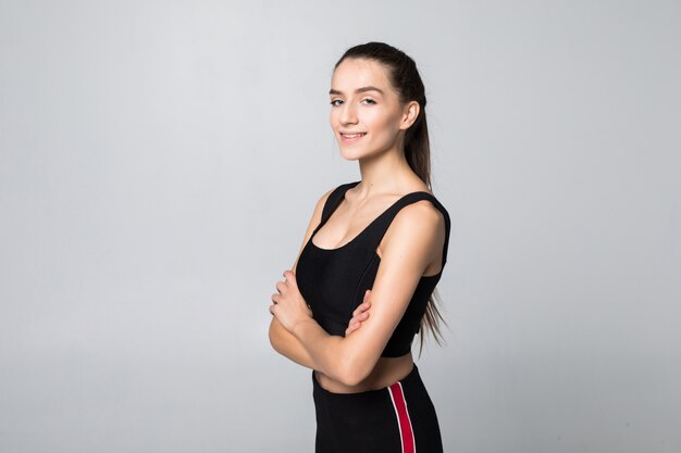 Retrato de mujer joven fitness con sus manos en las caderas mirando a cámara.