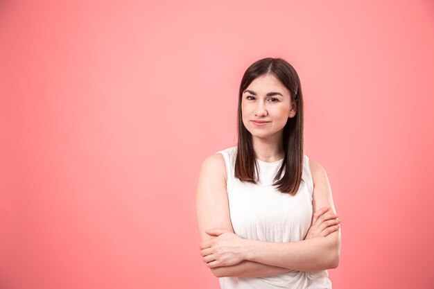 Retrato de una mujer joven en un fondo rosado aislado.