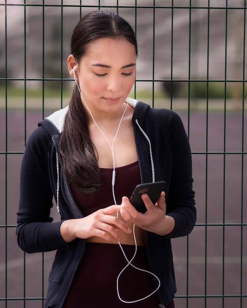 Foto gratuita retrato de mujer joven en forma con teléfono