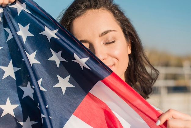 Foto gratuita retrato de mujer joven con gran bandera de estados unidos