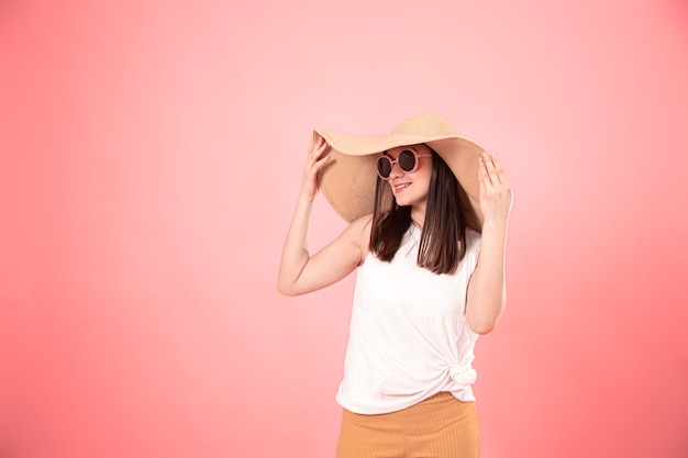 Retrato de una mujer joven con un gran sombrero de verano y gafas de sol