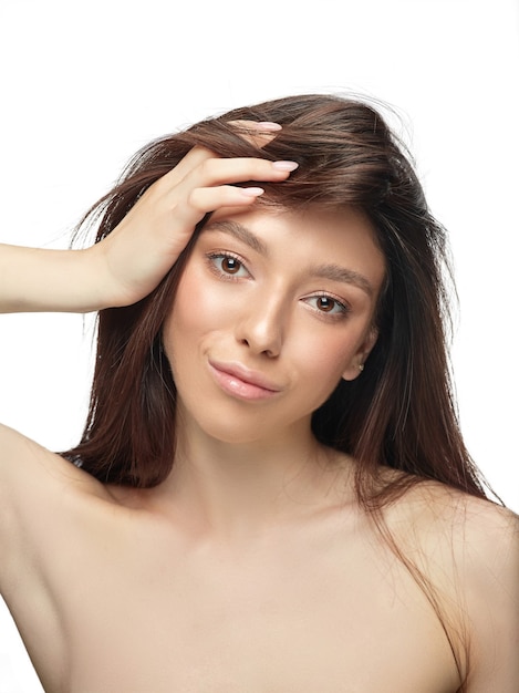 Retrato de mujer joven hermosa aislada en la pared blanca. Modelo de mujer sana caucásica y posando. Concepto de salud y belleza de la mujer, autocuidado, cuidado del cuerpo y de la piel.