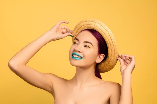 Retrato de mujer joven hermosa con maquillaje brillante aislado en amarillo