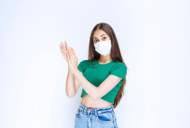 Retrato de mujer joven hermosa en máscara médica posando para la cámara.