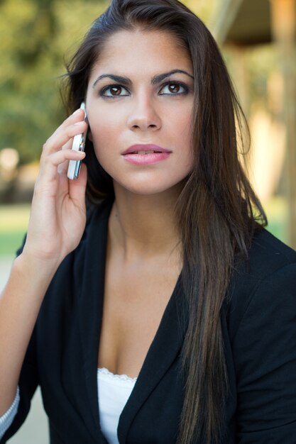 Retrato de mujer joven hermosa en el país con el móvil.