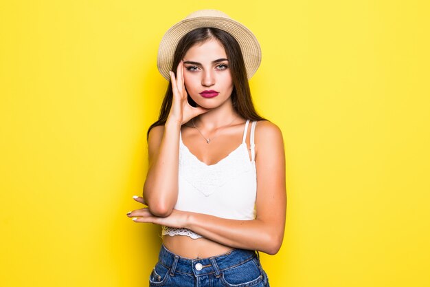 Retrato de mujer joven hermosa en la pared amarilla