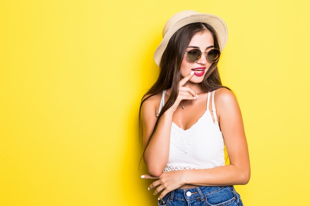 Retrato de mujer joven hermosa en la pared amarilla