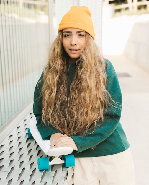 Foto gratuita retrato mujer joven hermosa con patineta