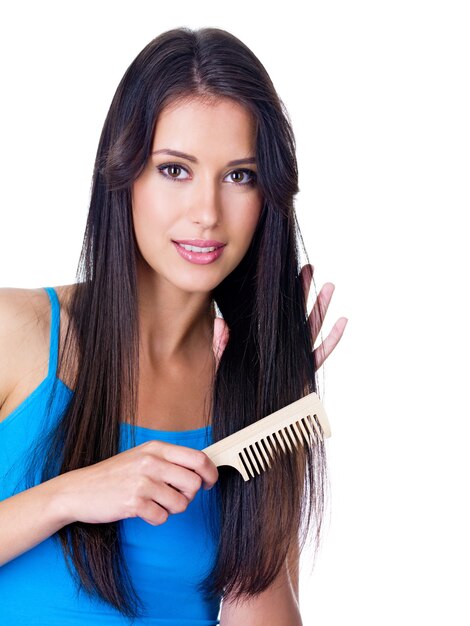 Retrato de mujer joven hermosa peinándose el pelo largo - aislado en blanco