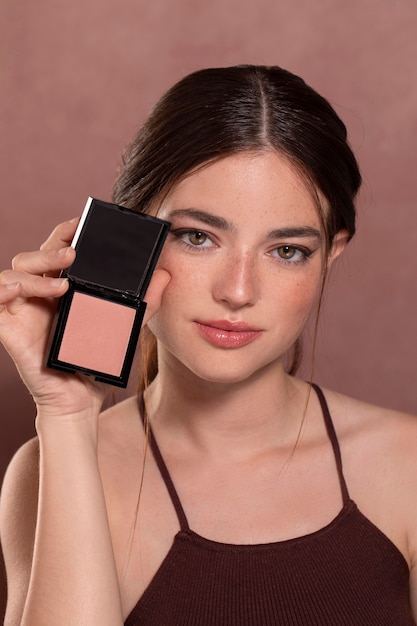 Retrato de mujer joven hermosa con un producto de maquillaje