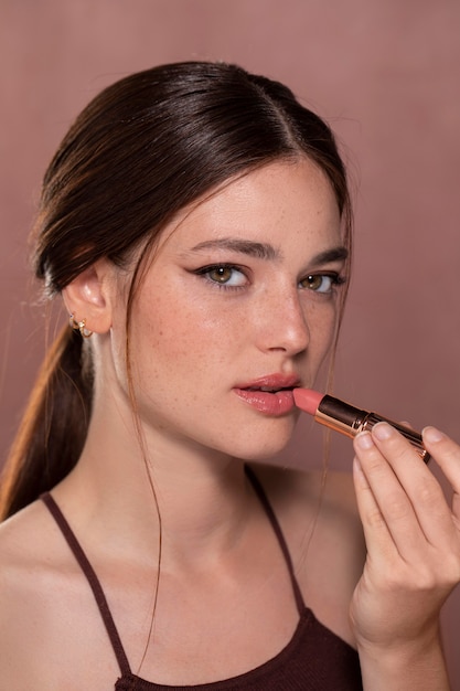 Retrato de mujer joven hermosa con un producto de maquillaje